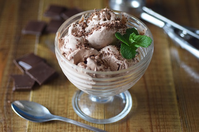 clear bowl of chocolate ice cream with mint on the side